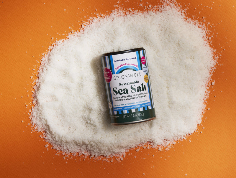 Sea Salt Mini Shaker on a pile of sea salt, orange background